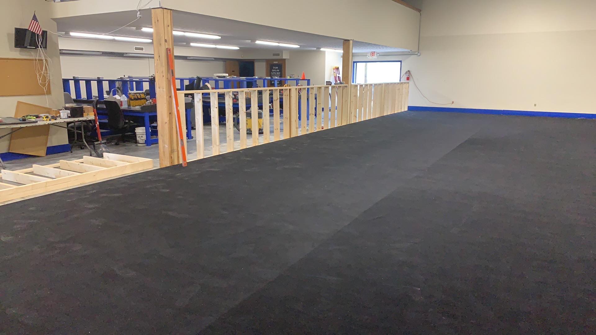 Carpet being installed over the completed Indy RC main track subfloor